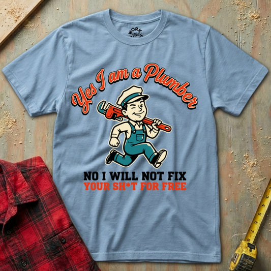 Blue t-shirt with a plumber graphic and text on a wooden surface with tools.