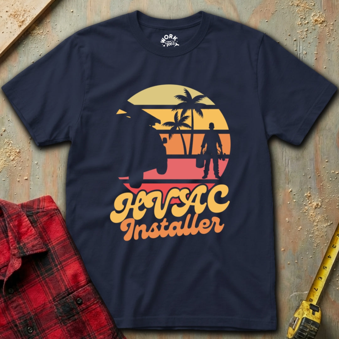 Navy blue t-shirt with 'HVAC Installer' graphic on a textured surface with tools.