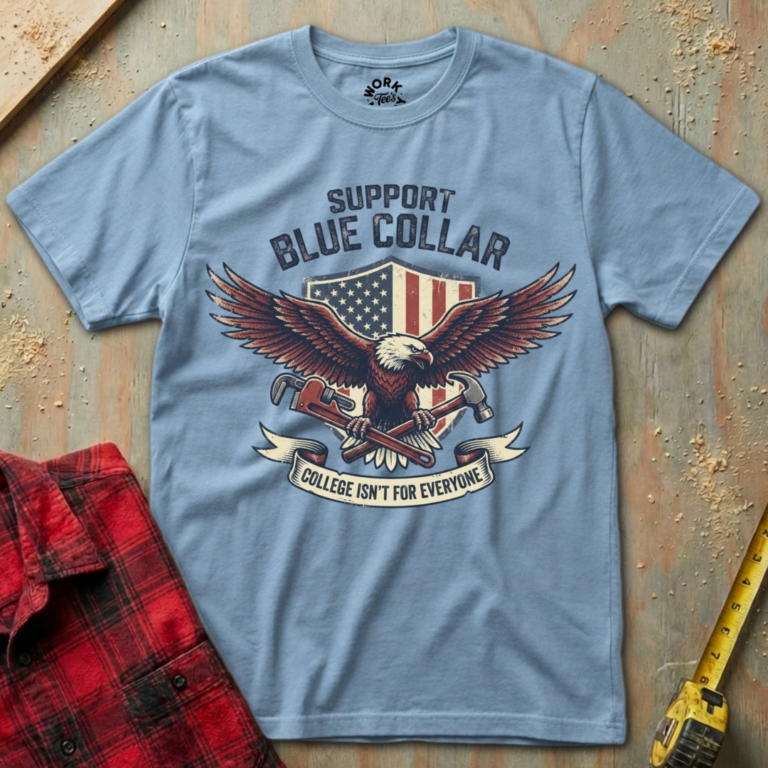 Blue t-shirt with eagle graphic and text on a wooden surface with plaid shirt and tape measure.