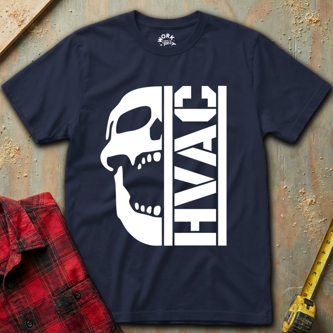 Navy blue t-shirt with white skull and 'HVAC' text on a textured surface with red plaid shirt and yellow tool in background