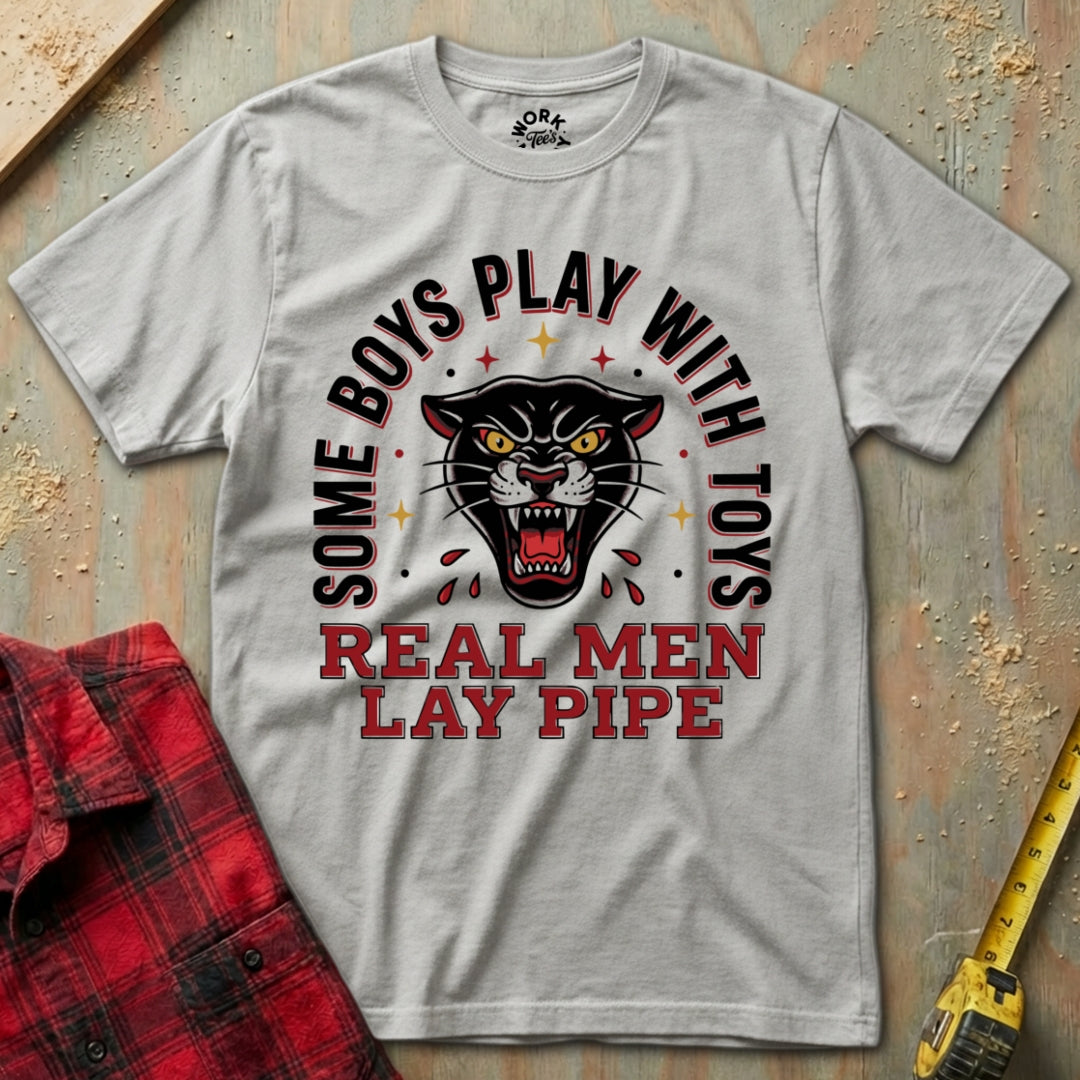 Gray t-shirt with panther graphic and text on a textured surface with plaid shirt and tape measure.