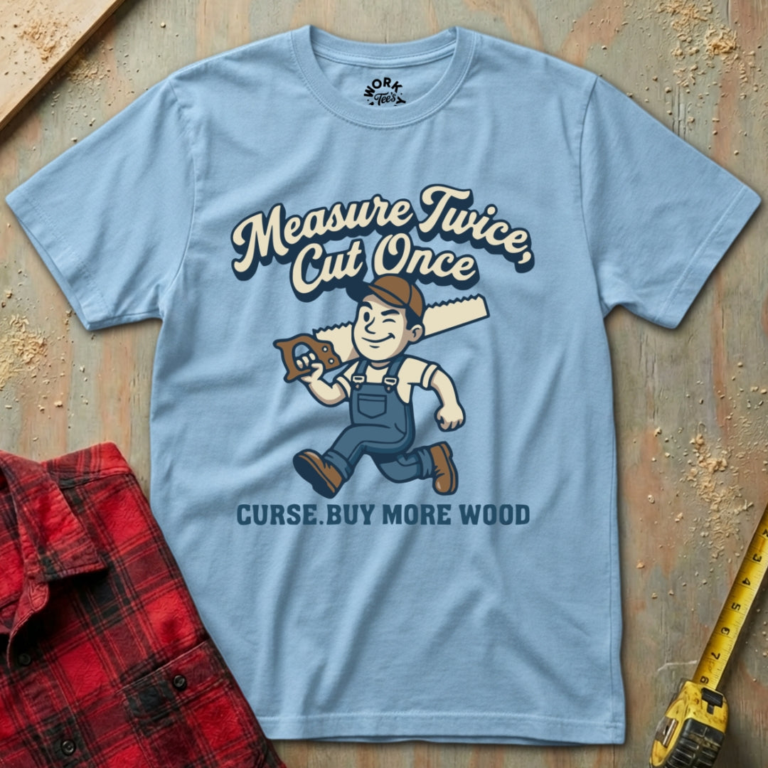 Light blue t-shirt with a graphic design of a cartoon character holding a hammer and text on a wooden background.