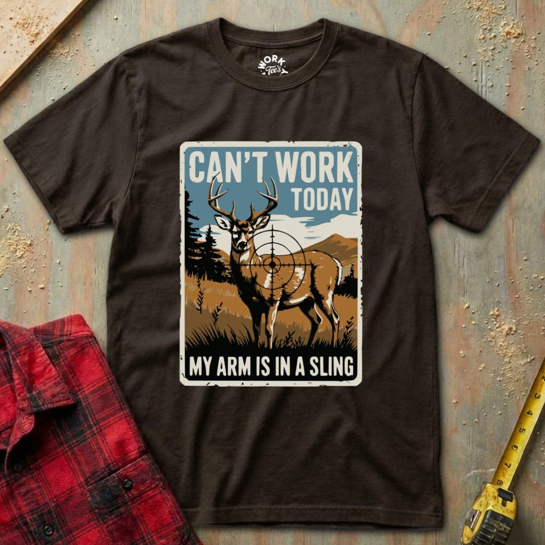 Brown t-shirt with a graphic of a deer and text 'Can't Work Today, My Arm is in a Sling' on a textured surface.