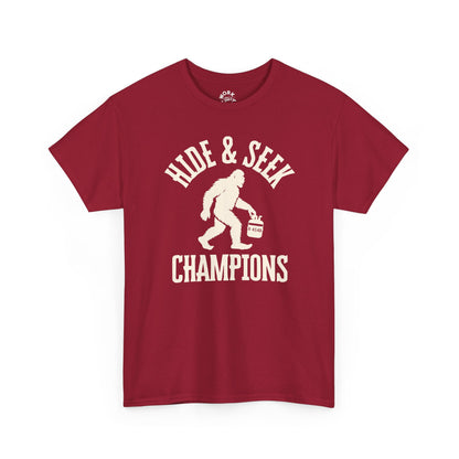 Red t-shirt with 'HIDE & SEEK CHAMPIONS' text and Bigfoot graphic on a white background