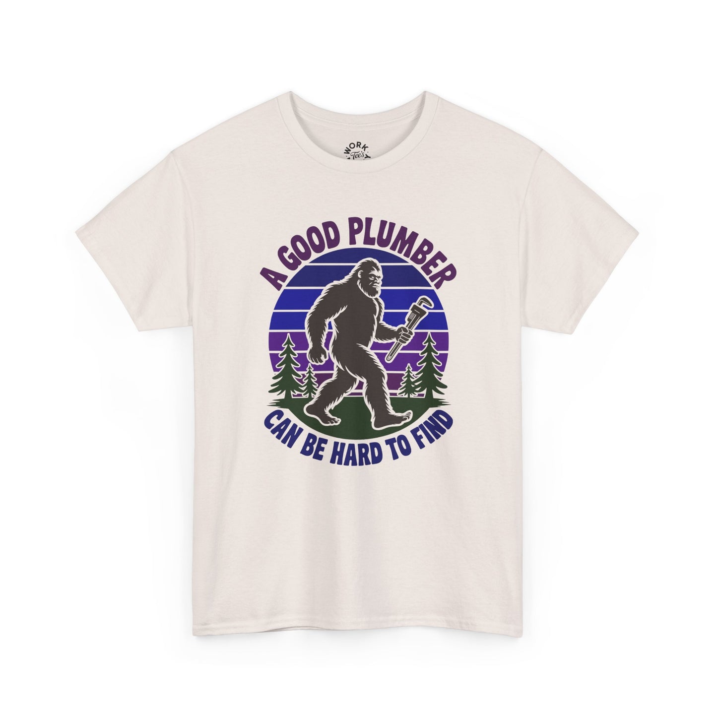 Beige t-shirt with a graphic of a bigfoot holding a wrench and text 'A good plumber can be hard to find' on a white background.