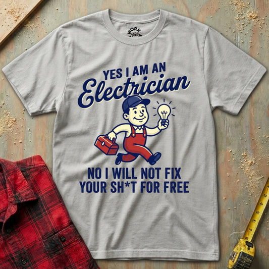 Gray t-shirt with electrician graphic and text on a textured surface with tools.