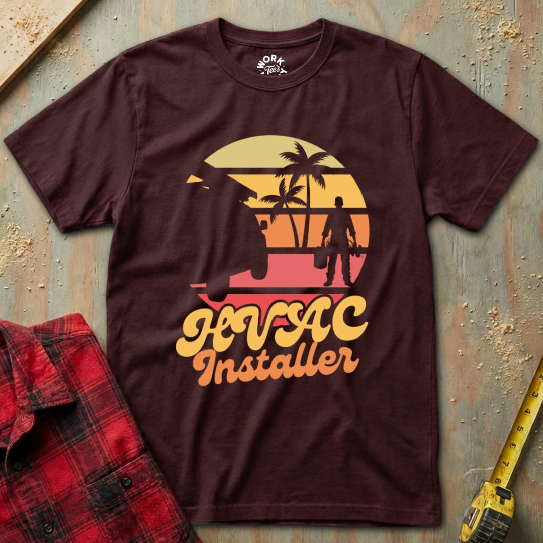 Maroon t-shirt with 'HVAC Installer' graphic on a textured surface with tools.