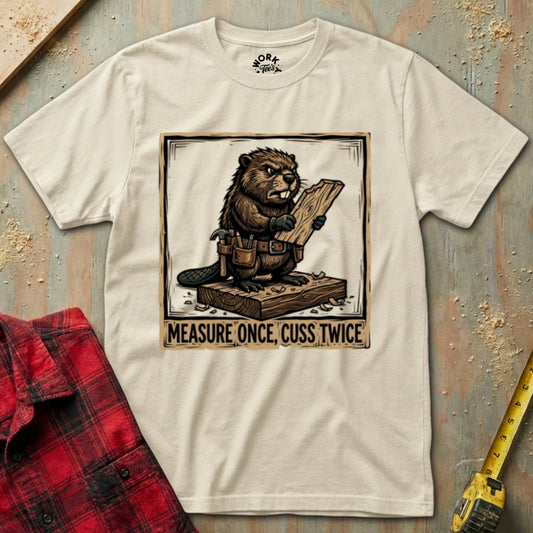 Beaver graphic t-shirt with 'Measure Once, Cuss Twice' text on a textured surface with plaid shirt and tape measure.