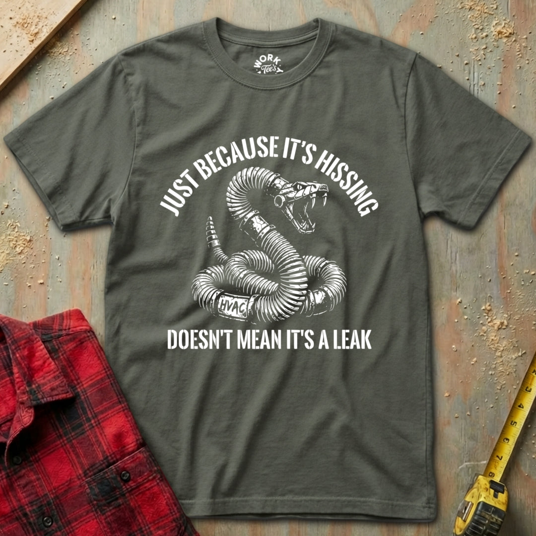 Gray t-shirt with snake graphic and text on a textured surface with red plaid shirt and yellow tool.
