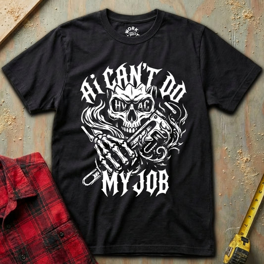 Black t-shirt with skull graphic and text 'I can't do my job' on a textured surface with a red plaid shirt and yellow tool.