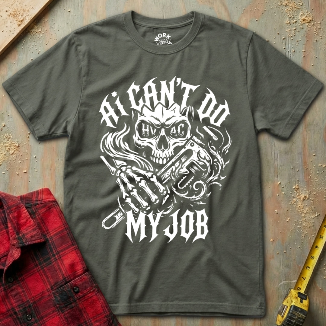 Gray t-shirt with skull and crossbones design and text on a textured surface with plaid shirt and tape measure.