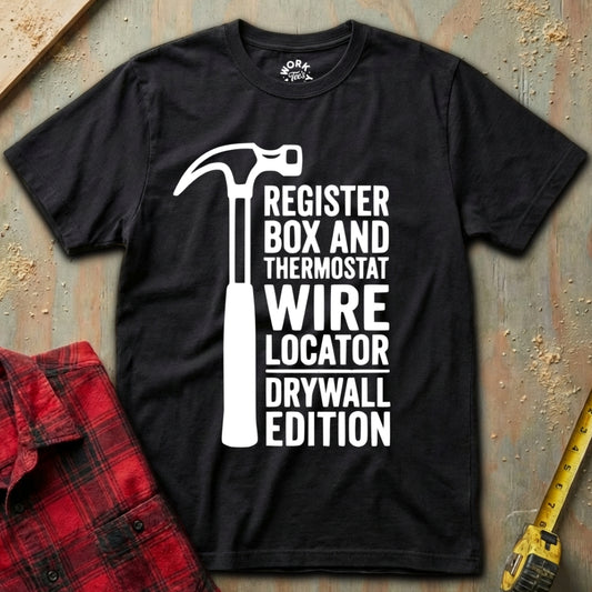 Black t-shirt with white graphic and text on a textured surface with tools.