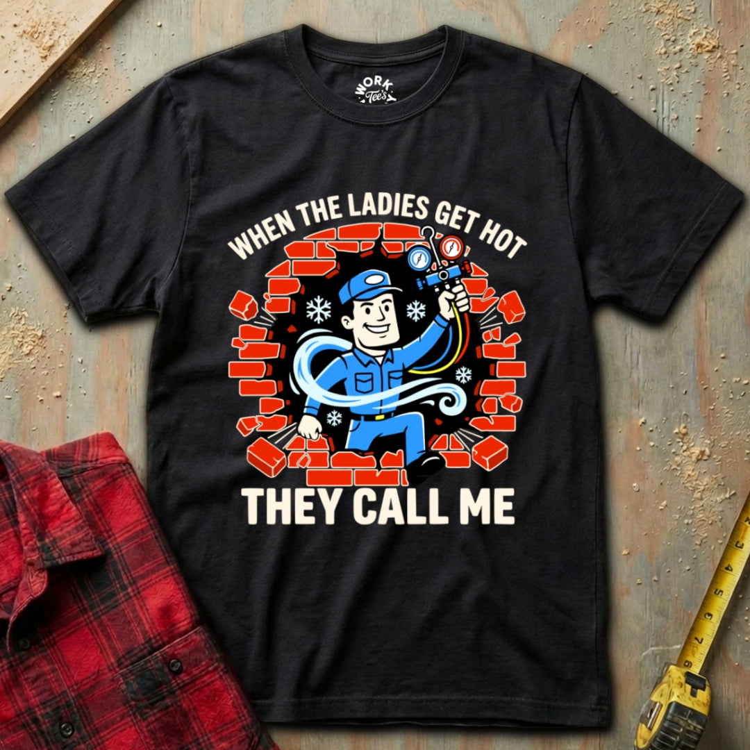 Black t-shirt with a graphic design and text on a textured surface with a red plaid shirt and yellow tool in the background.