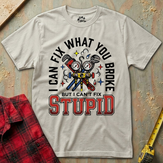 Gray t-shirt with graphic design and text on a textured surface with tools.