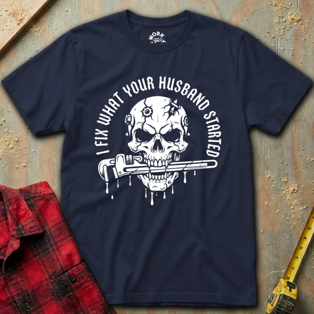 Navy blue t-shirt with skull graphic and text on a textured surface with tools.