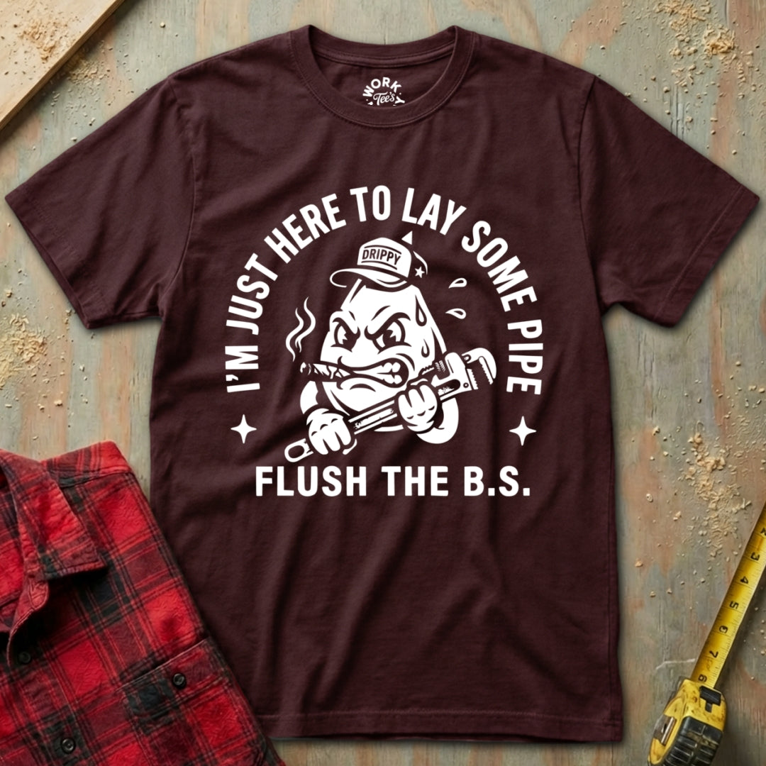 Maroon t-shirt with graphic design and text on a textured surface with plaid shirt and tape measure.
