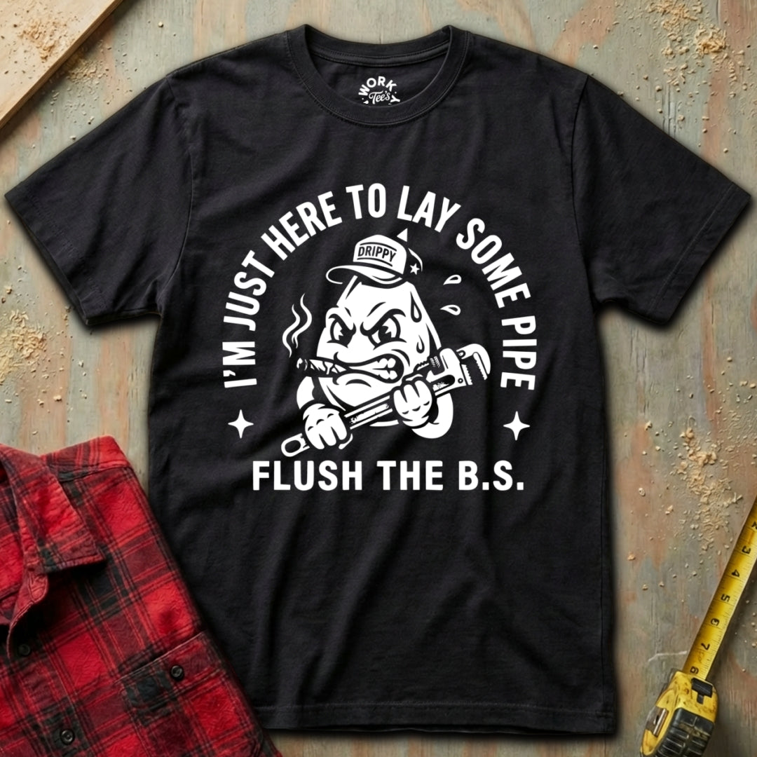 Black t-shirt with graphic design and text on a textured surface with plaid shirt and tape measure.