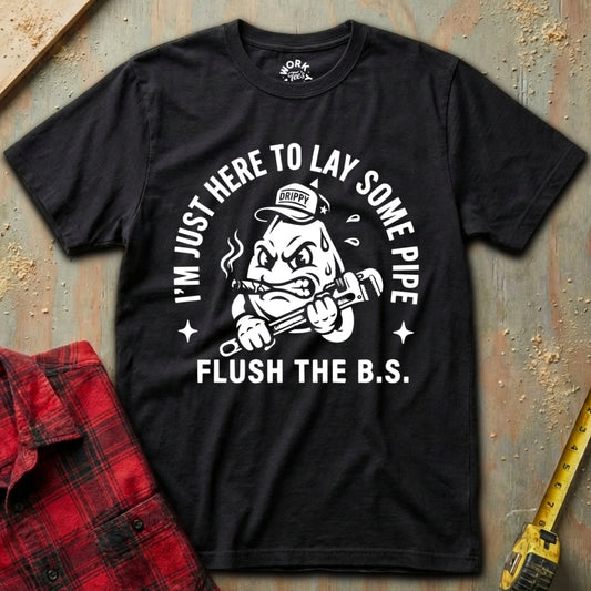 Black t-shirt with graphic design and text on a textured surface with plaid shirt and tape measure.