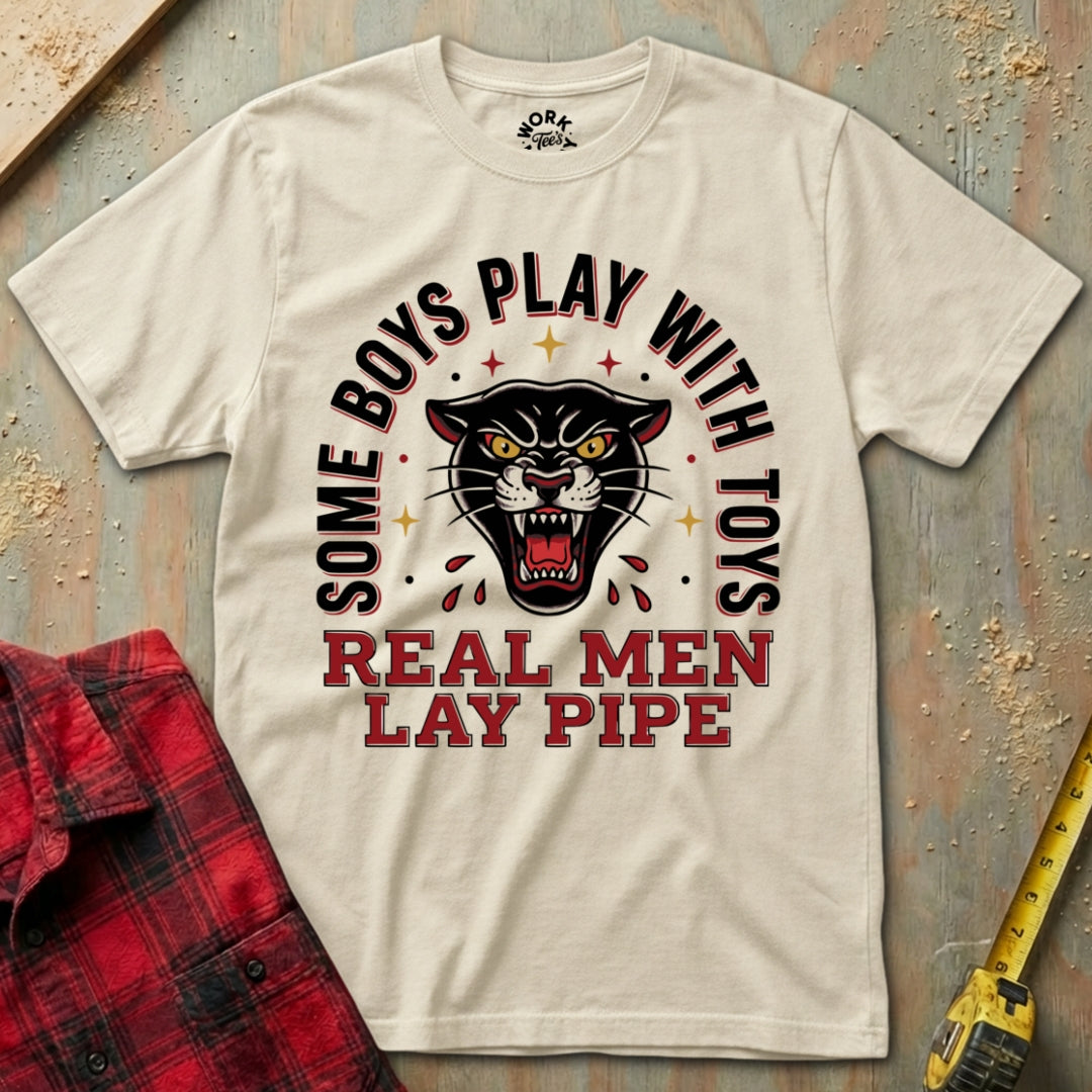 Beige t-shirt with panther graphic and text on a textured surface with plaid shirt and tape measure.