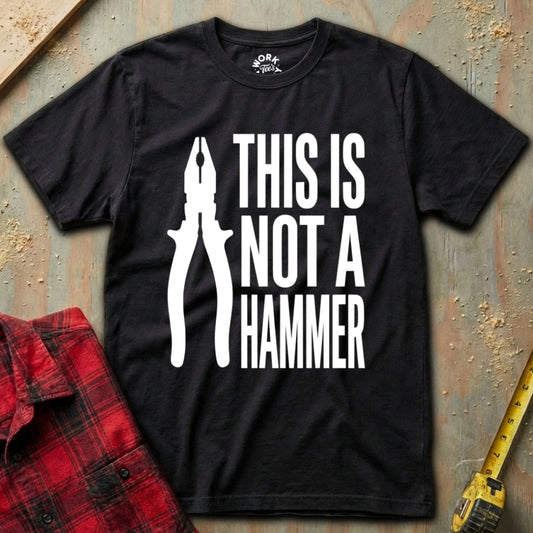 Black t-shirt with white graphic and text 'THIS IS NOT A HAMMER' on a textured surface.