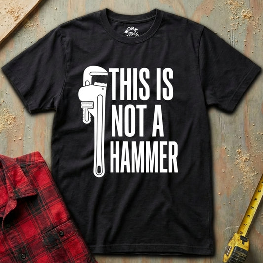 Black t-shirt with 'This is not a hammer' graphic and text on a textured surface.