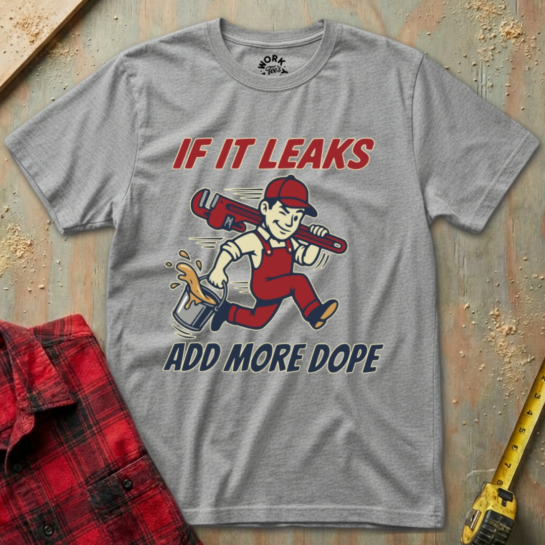 Gray t-shirt with a graphic and text 'If it leaks add more dope' on a textured surface.