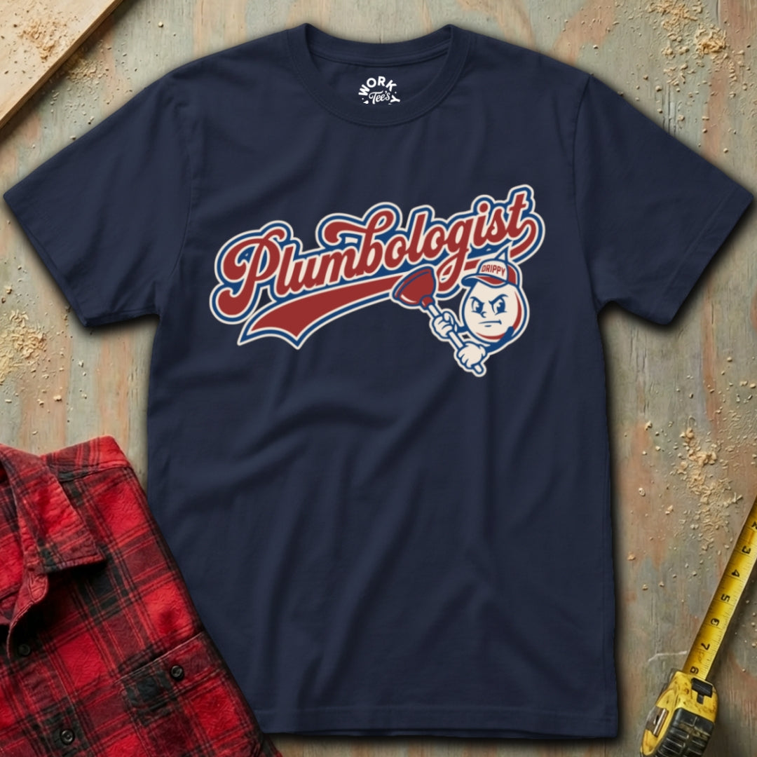 Navy blue t-shirt with 'Plumbologist' graphic on a textured surface with tools.