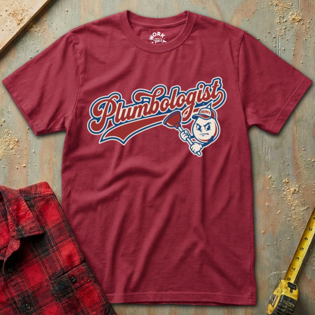 Red t-shirt with 'Plumbologist' graphic on a textured surface with tools.