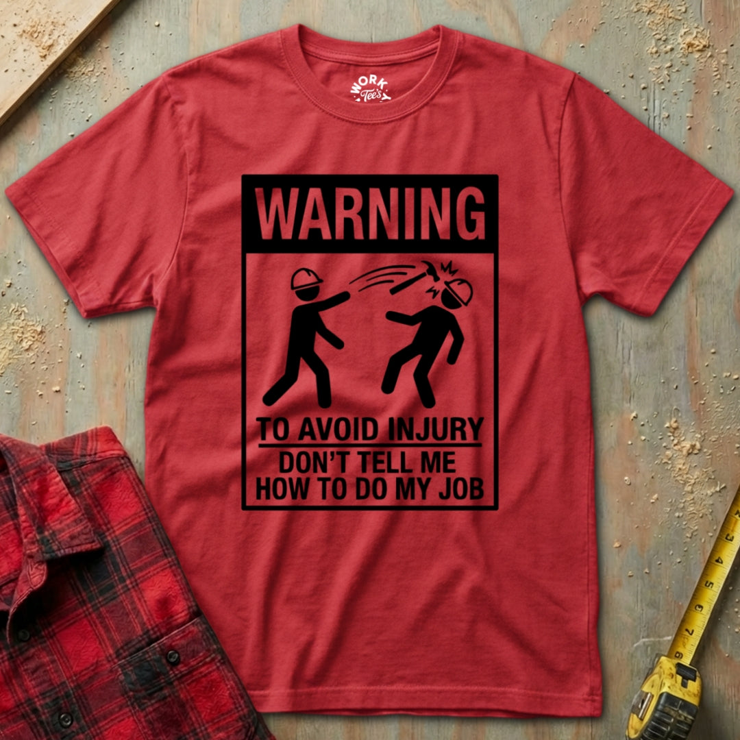 Red t-shirt with a humorous warning graphic on a textured surface.
