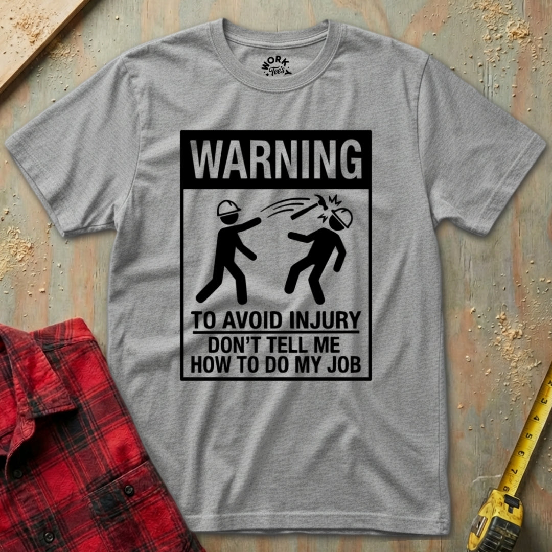 Gray t-shirt with a humorous warning graphic and text on a wooden surface.
