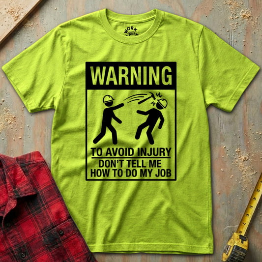 Bright green t-shirt with a warning sign graphic on a textured surface.