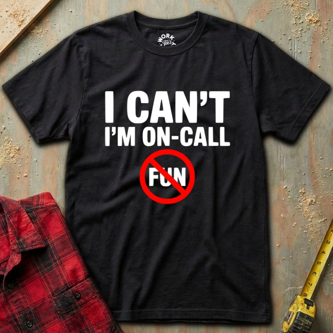 Black t-shirt with 'I Can't I'm On-Call Fun' text on a textured surface with a red shirt and tape measure.