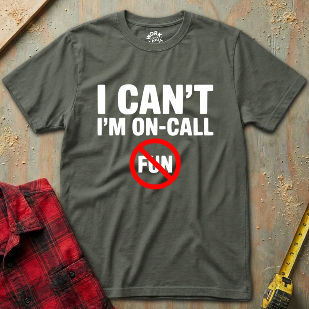 Military Green t-shirt with 'I Can't I'm On-Call Fun' text on a textured surface with a red shirt and tape measure.