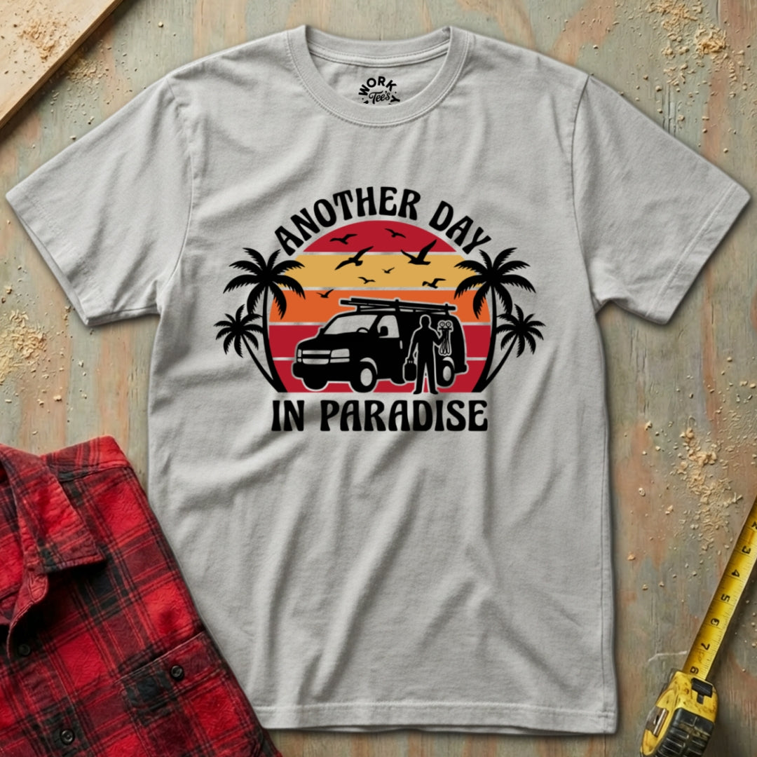 Gray t-shirt with 'Another Day in Paradise' graphic design on a textured surface.