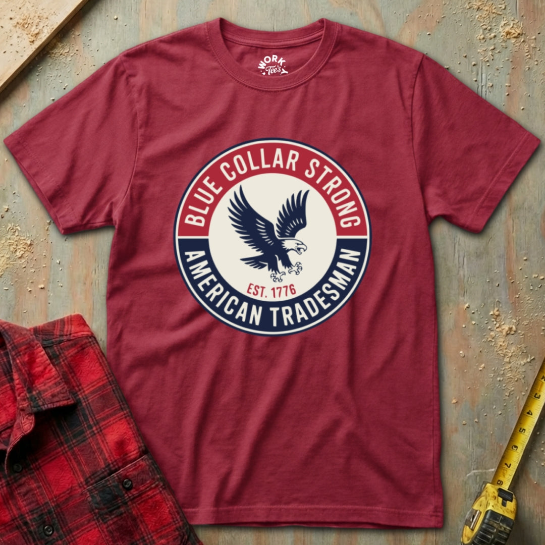 Red t-shirt with 'Blue Collar Strong American Tradesman' graphic on a textured surface.