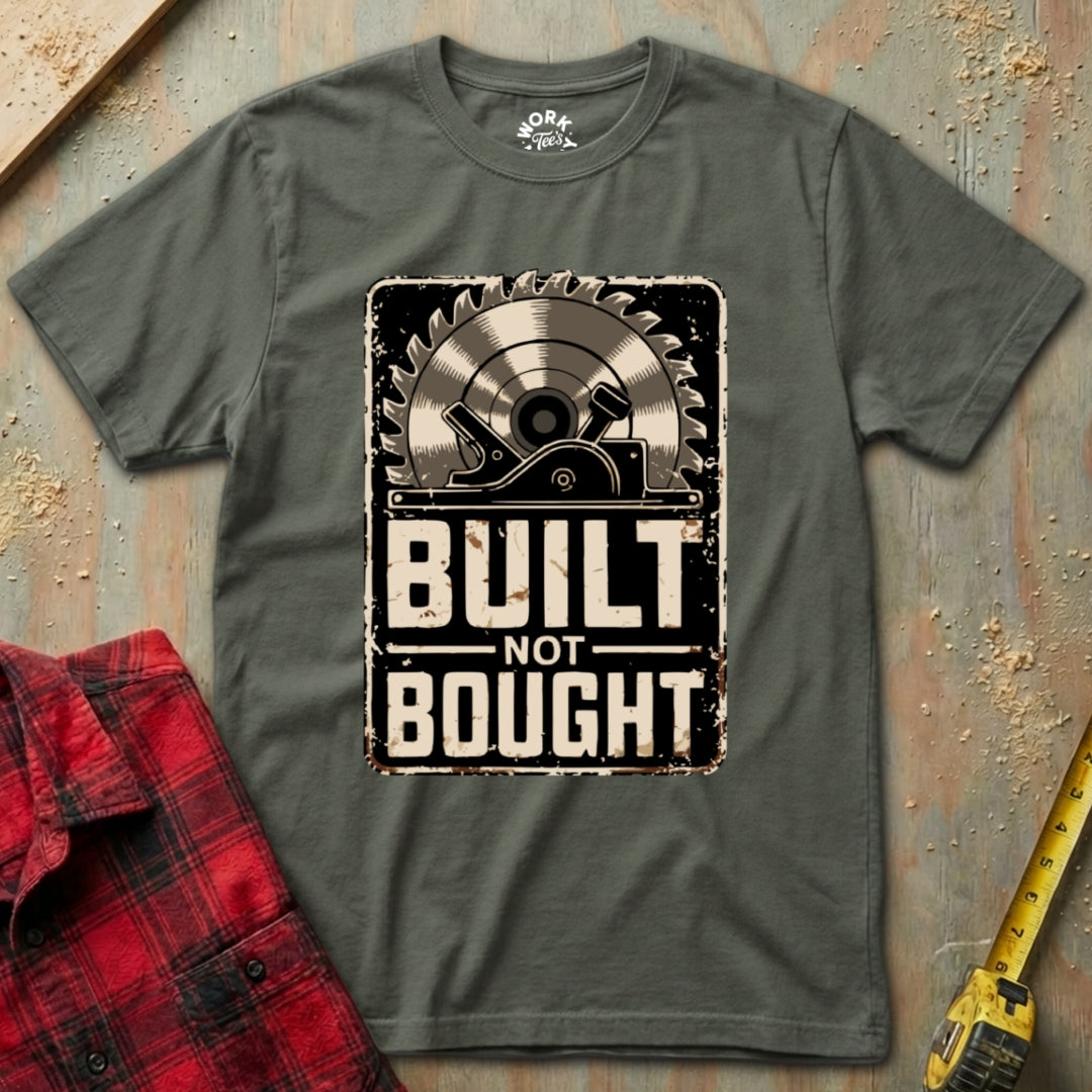 Gray t-shirt with 'Built Not Bought' graphic on a rustic background