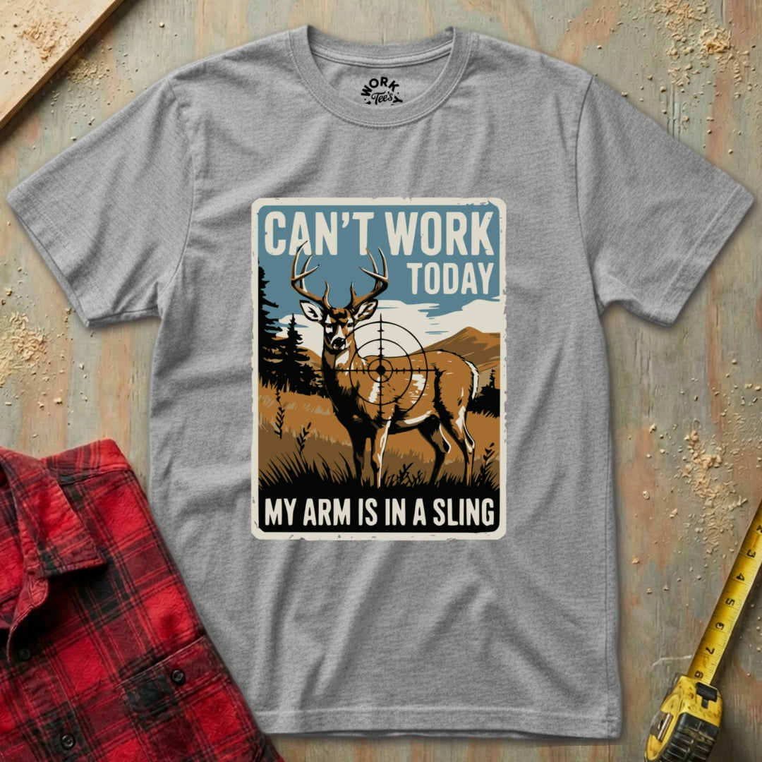 Gray t-shirt with a graphic of a deer and text 'Can't Work Today, My Arm is in a Sling' on a textured surface.