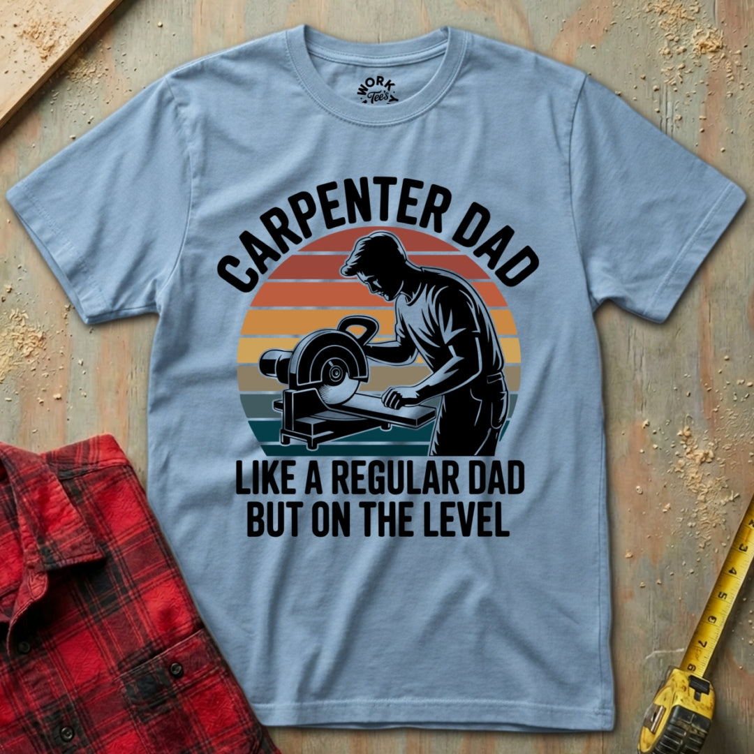 Gray t-shirt with 'Carpenter Dad' graphic and text on a wooden surface with tools.