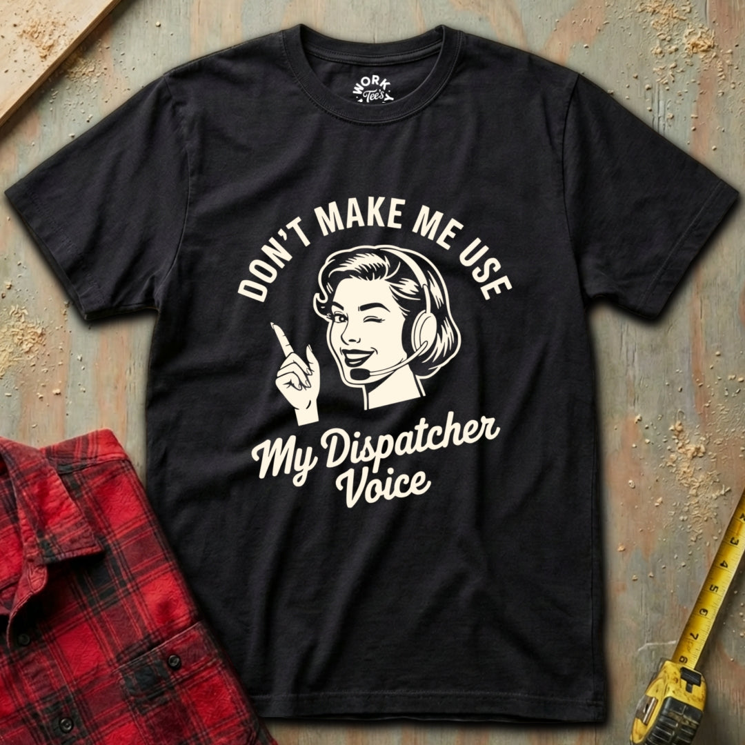 Black t-shirt with white graphic and text on a textured surface with a red plaid shirt and yellow tool in the background.