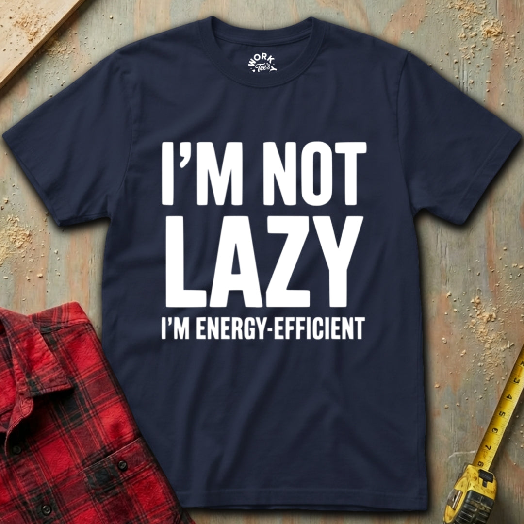 Navy blue t-shirt with 'I'm not lazy, I'm energy-efficient' text on a textured surface with a red plaid shirt and yellow tool in the background.