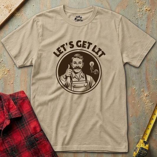 Beige t-shirt with graphic design and text 'Let's Get Lit' on a rustic wooden surface.