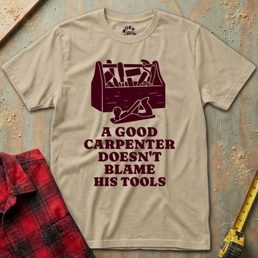 Beige t-shirt with a graphic and text on a wooden background with tools.