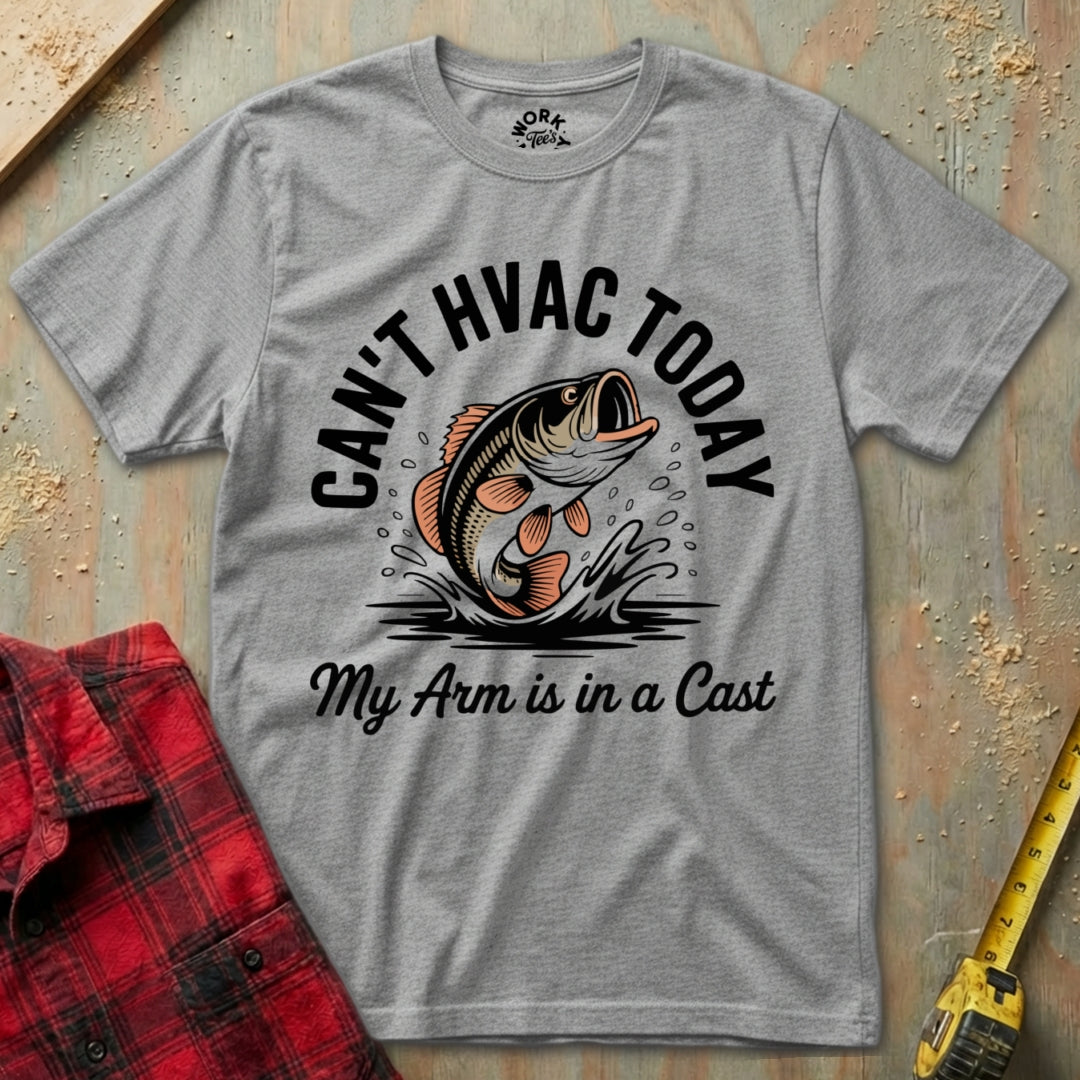 Gray t-shirt with a fishing graphic and text on a wooden surface with a red flannel shirt and tape measure.