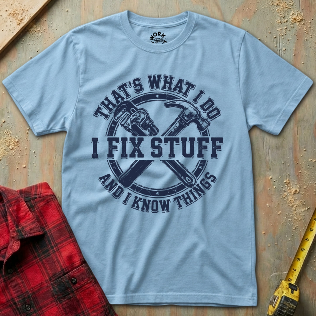 Light blue t-shirt with graphic design and text on a wooden surface with tools.