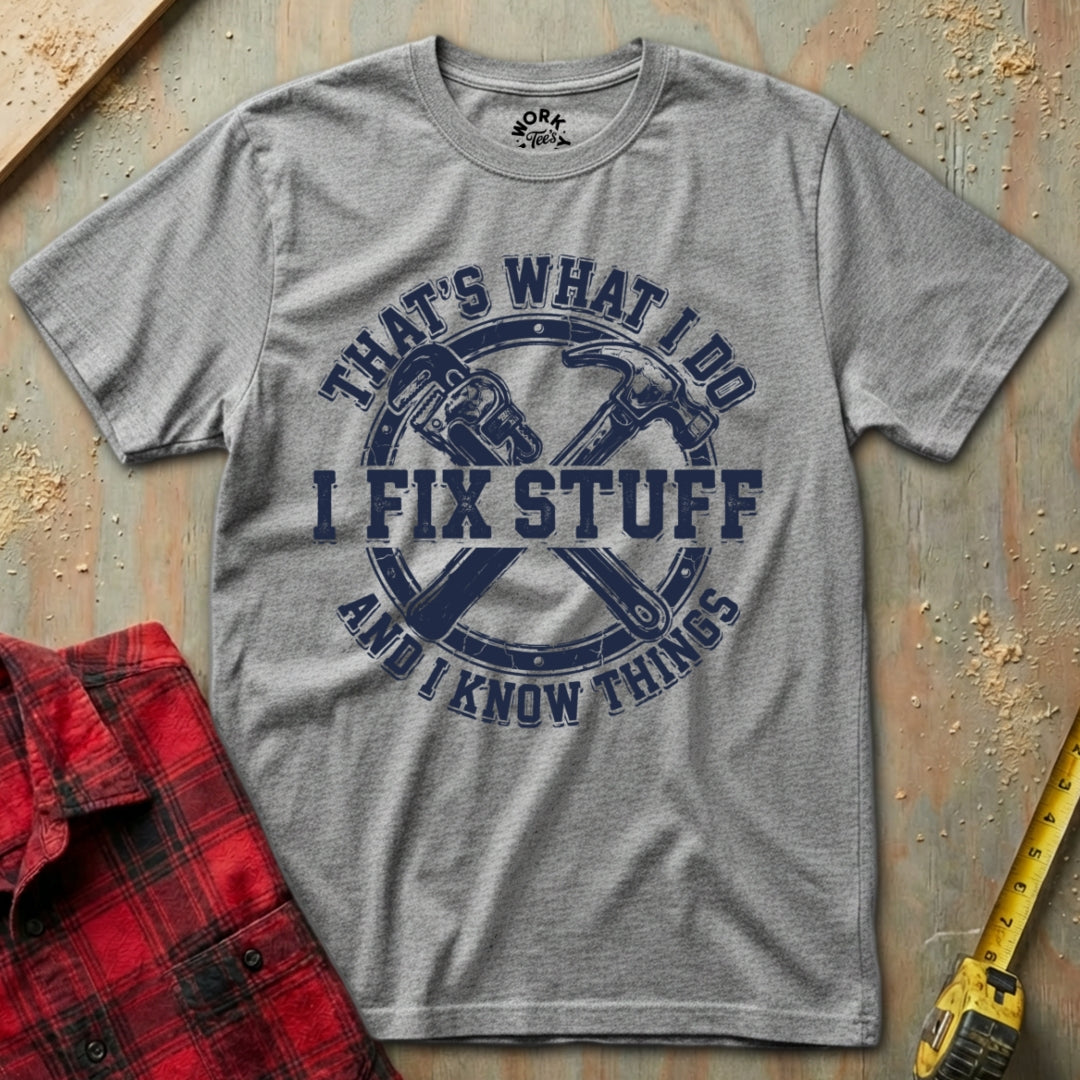 Gray t-shirt with blue graphic and text 'I Fix Stuff and I Know Things' on a textured surface with tools.