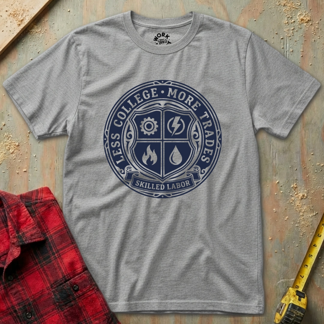 Gray t-shirt with blue emblem and text on a textured surface with red plaid shirt and yellow tool in background