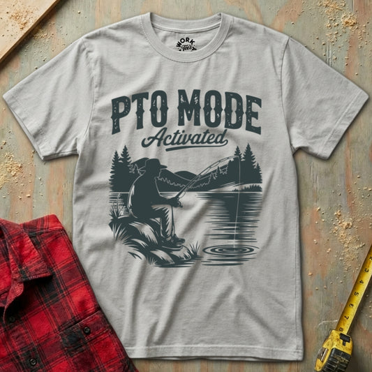 Gray t-shirt with 'PTO Mode Activated' graphic on a wooden surface with plaid shirt and drill.