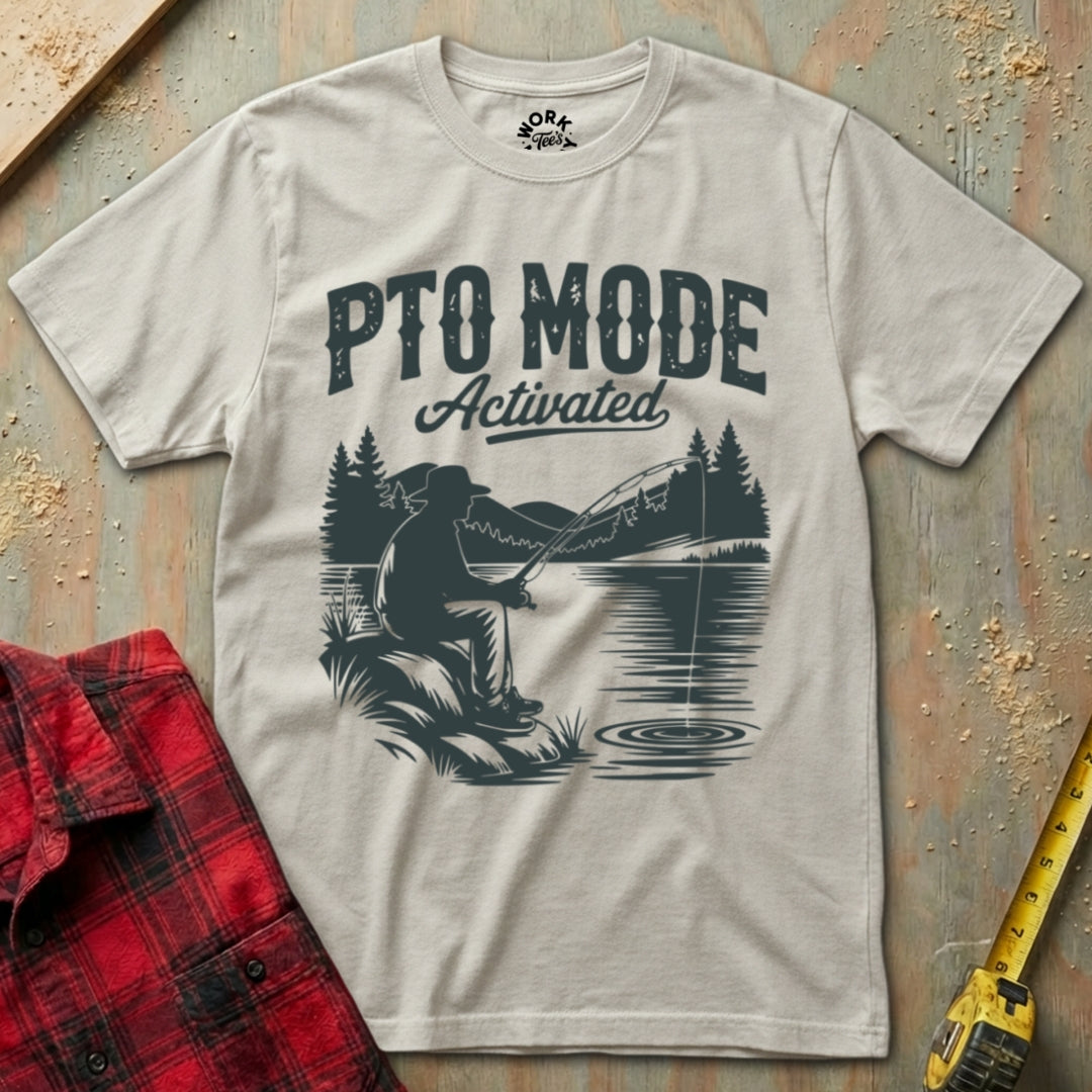 T-shirt with 'PTO Mode Activated' graphic design on a textured surface with plaid shirt and tape measure.