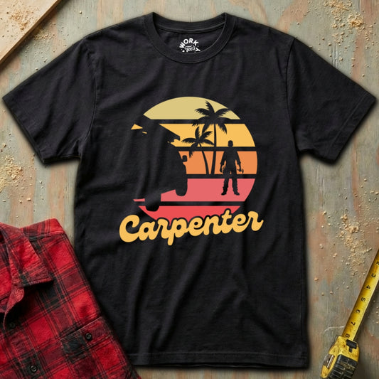 Black t-shirt with 'Carpenter' graphic design on a textured surface with plaid shirt and tape measure.
