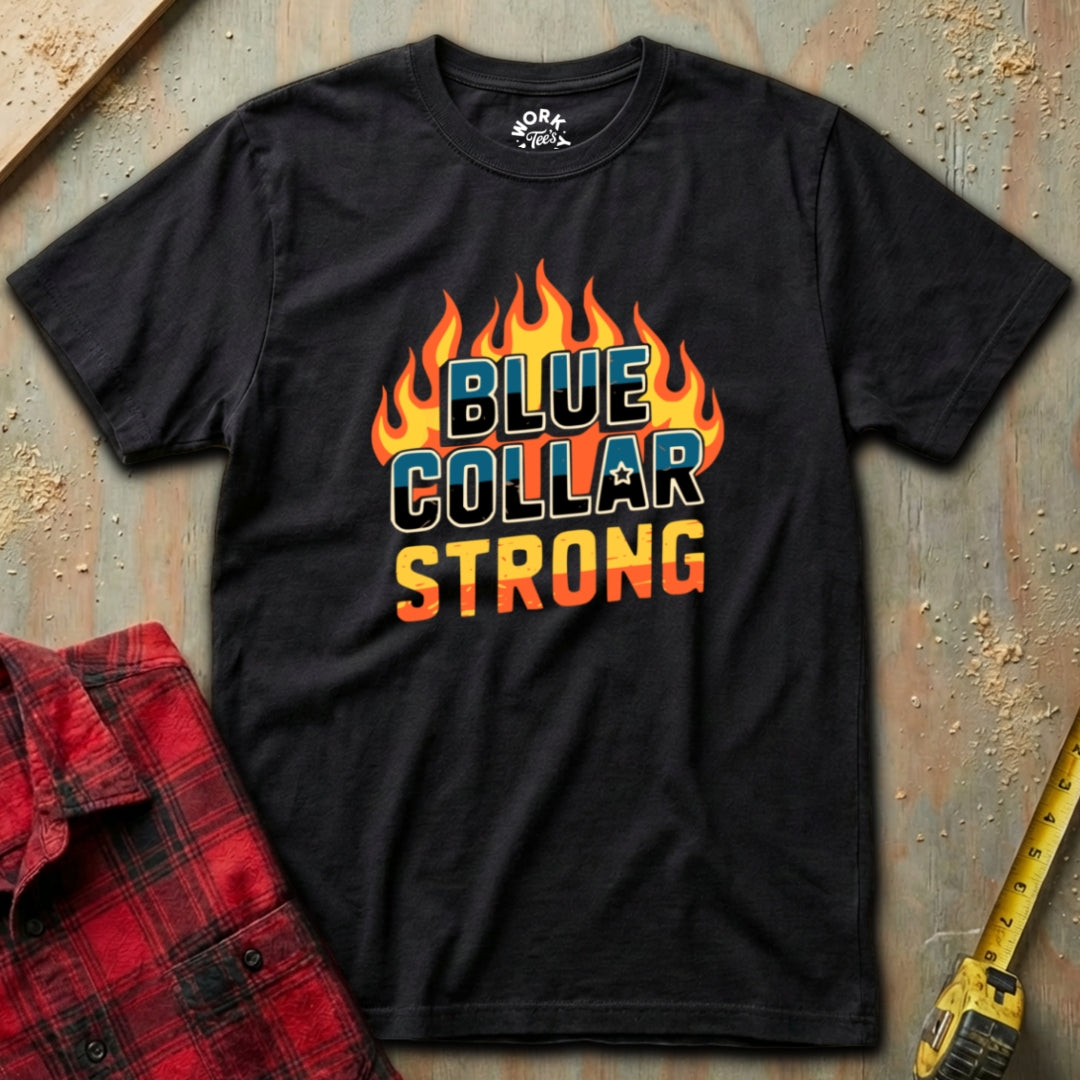 Black t-shirt with 'Blue Collar Strong' graphic on a textured surface with a red plaid shirt and yellow tool in the background.